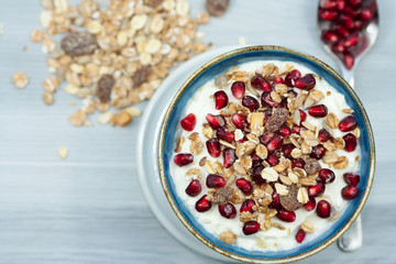 Bowl of greek yogurt with pomegranate and muesli.