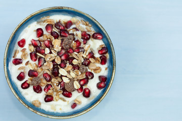 Bowl of greek yogurt with pomegranate and muesli.