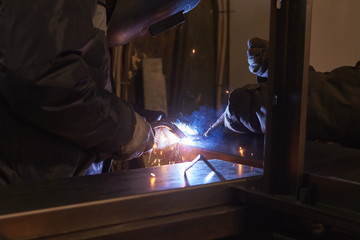welder welds a metal frame for the power plant.