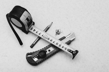 Table composition with roulette, pencil, cleric knife and shavings in grayscale. Monochrome...