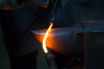 the blacksmith forged a strip of hot metal. close up