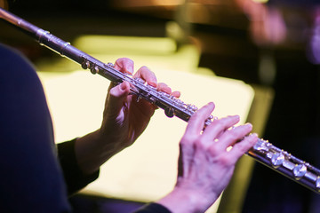 hands playing flute at orchestra concert