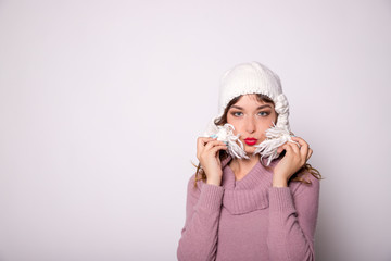 Beautiful woman winter portrait. Smiling girl wearing warm clothes. Fun, kiss,positive emotions concept.Copy space. Winter shopping,Sale.Winter woman wearing warm winter clothing, sweater and wool cap