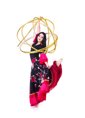 A young,smiling girl in a long skirt dancing with a Hoop.