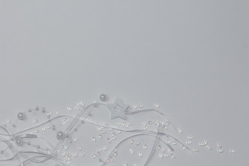 White pearl beads decoration with stars and satin ribbons on white background.