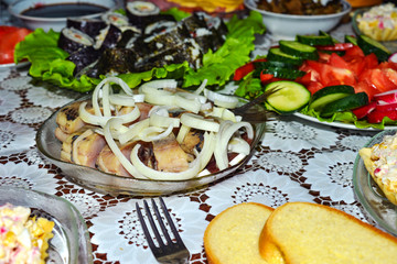 Marinated herring with onion cut into pieces in a plate poured with sunflower oil.