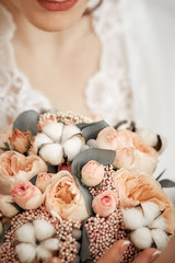 the bride is holding her bouquet on the background of a wedding dress