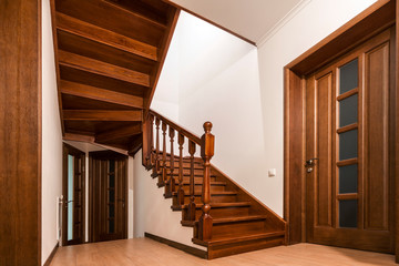 Modern brown oak wooden stairs  and doors in new renovated house interior