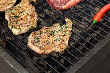 Beef steaks on the grill with flames.