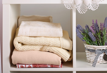 shelves with various things in the room - flowers, knitted blankets