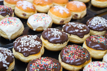 assorted donuts with chocolate frosted, pink glazed and sprinkles donuts
