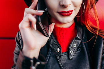 Young stylish hipster girl with red hair talking on the phone