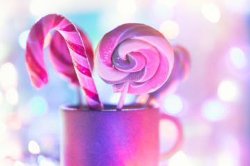 Christmas background. Caramel, bokeh, blur. Candy cane on blurred Christmas lights background