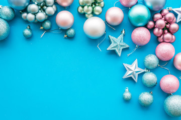 Toys for New Year tree 2019 background. Blue and pink balls and stars on blue background top view space for text border