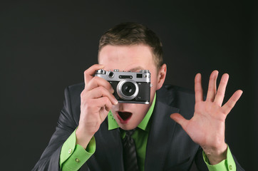 Spy agent with photo camera is photographing a compromising evidence isolated on the black...