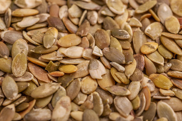 Heap of fresh pumpkin seeds background. Close up