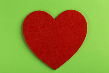 Red felt heart on bright green background. St. Valentine's day