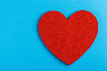 Red felt heart on bright blue background. St. Valentine's day