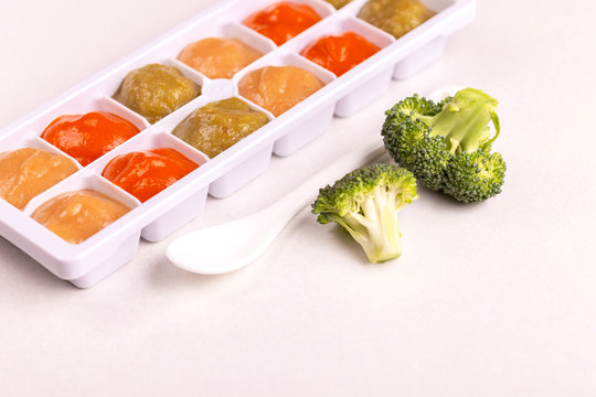 Multicolored pureed baby food in ice cube trays