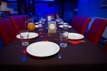 Restaurant table served with plates and glasses.Table prepared for party in cafe or restaurant. Catering and celebration concept. Celebrate birthday in restaurant. Family holiday or corporate