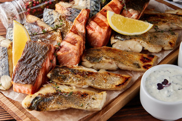 Assorted grilled fish on wooden board