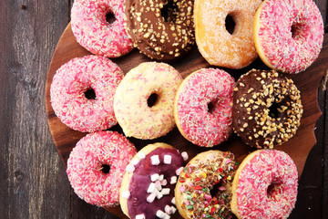 assorted donuts with chocolate frosted, pink glazed and sprinkles donuts