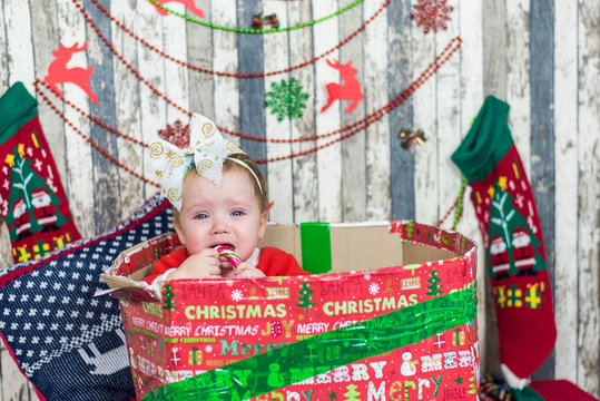 Merry Christmas and Happy Holidays! Xmas Cute little baby in Christmas costume in box cry at home.