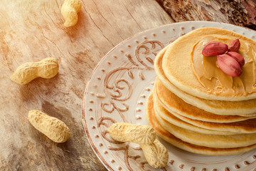 Stack Of Hot Pancakes On The Plate. Pancakes With Peanuts And Peanut Butter For A Breakfast. Close-up.