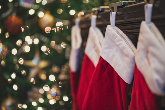 Christmas Stockings Hanging On Mantle Near Tree