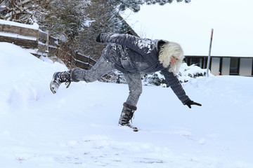 Gefährlich glatte Straßen und Gehwege im Winter. Eine Frau rutscht auf einer schneeglatten...
