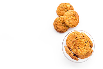 Homemade oatmeal cookies in glass bowl on white background top view copy space