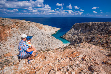 Father with his little son looking at Seitan limania beach on Crete island with azure clear water, Greece, Europe