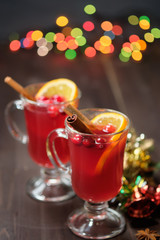 Mulled wine on a wooden background with candles, pine branches and Christmas lights. Selective focus