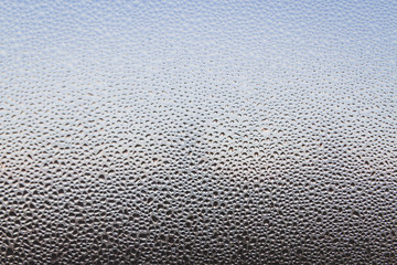 The frozen drops on the patterned frosty winter window