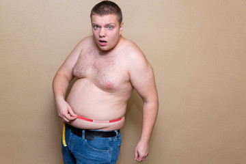 A man measures his fat belly with a meter