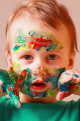 Close up portrait of hands and face painted in colorful paints. Children's meykap. Humorous portrait.