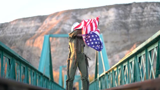 Female astronaut on train tracks with american flag.