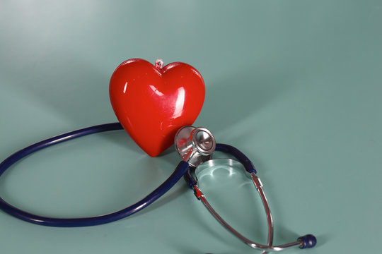 Red heart and a stethoscope on desk