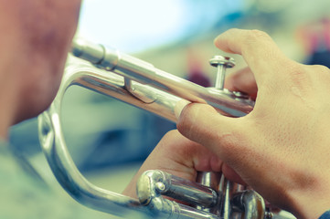 Obraz premium Close up of selective focus of man in national military parade playing the trumpet during the diablada festival