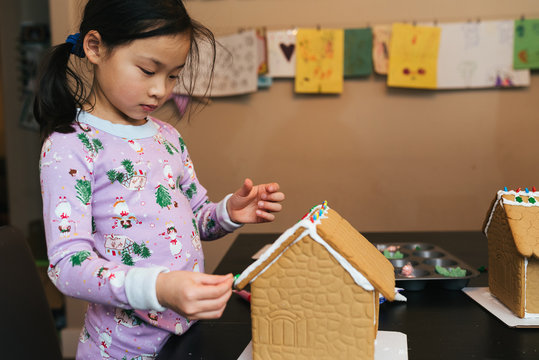 Young girl decorating a ginger bread house