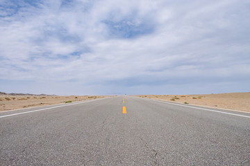 Road leading to horizon in gobi desert near Dunhuang, Gansu, in northwestern China