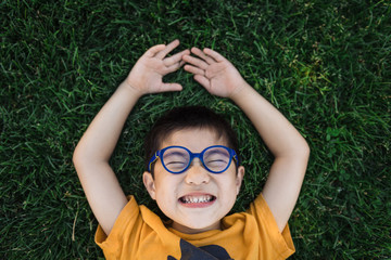 Young smiling boy lying on the grass