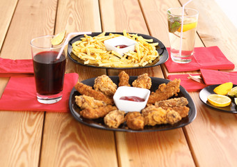 potatoes and wings with sauce in the plate on the table