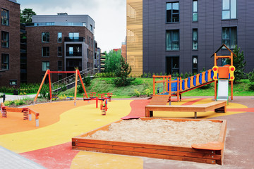 Fototapeta na wymiar Children playground in European modern residential buildings quarter