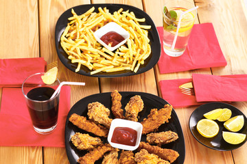 potatoes and wings with sauce in the plate on the table