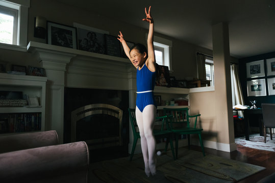 Young girl practicing gymnastics at home
