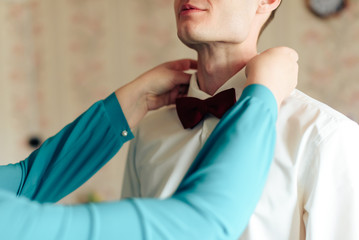 the morning of the groom, a handsome guy in a suit with a bow tie