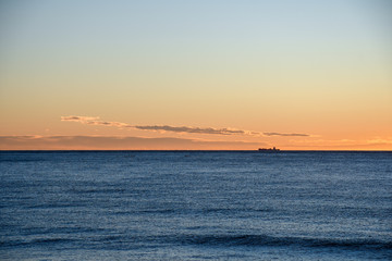 View of Mediterranean Sea with a ship on the horizon at sunset, Alassio, Liguria, Italy