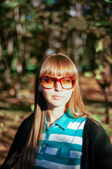 Portrait of young girl wearing sunglasses in park in Moscow