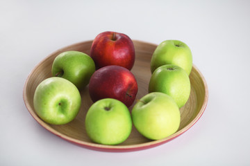 wooden plate with ripe fresh red and green apples